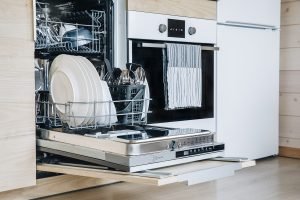 Open Dishwasher with Clean Glasses and Dishes Close Up in Modern Kitchen